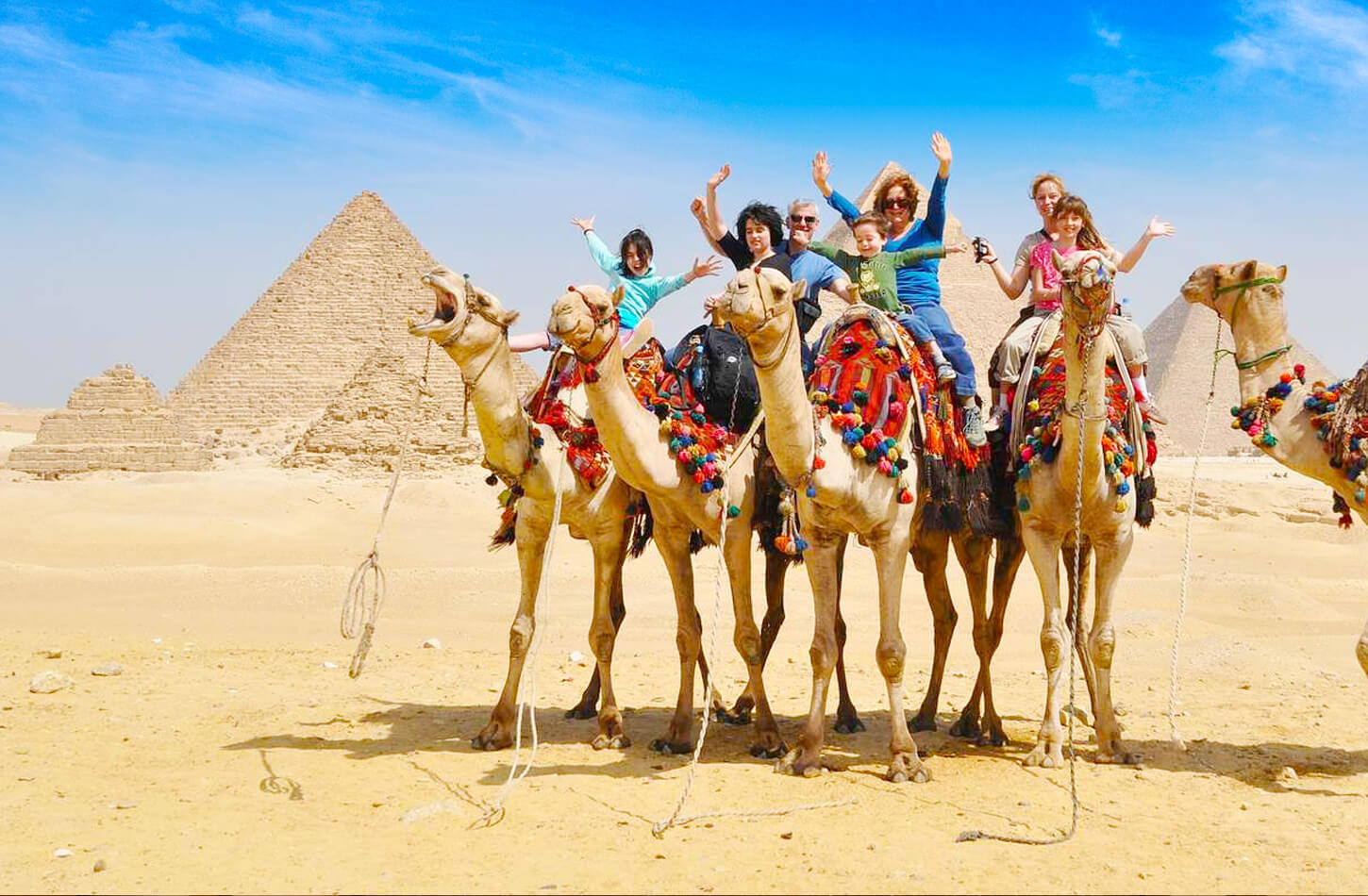 Una Foto Maravillosa De Una Familia Dentro De Las Piramides Y Cabalgando Camellos
